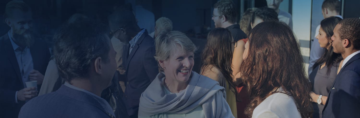 A group of people are chatting at a gathering.