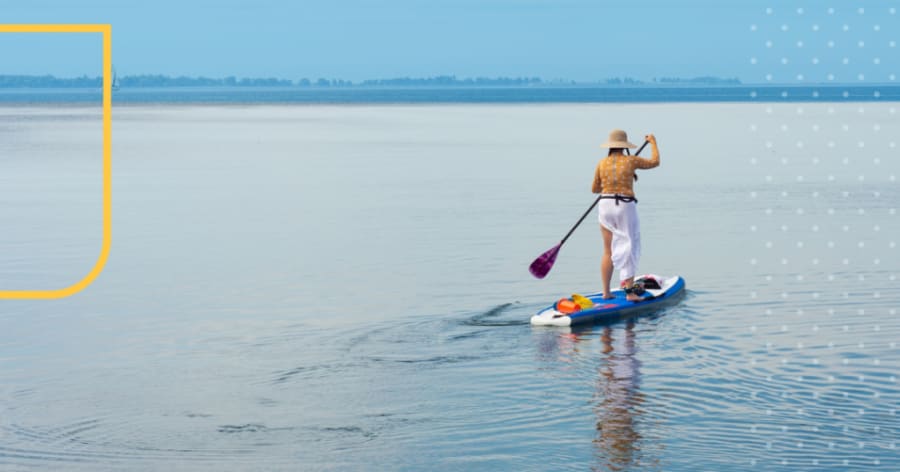 A person is standing on a board paddling