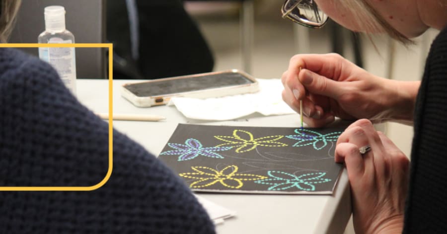 Someone does dot art on black paper