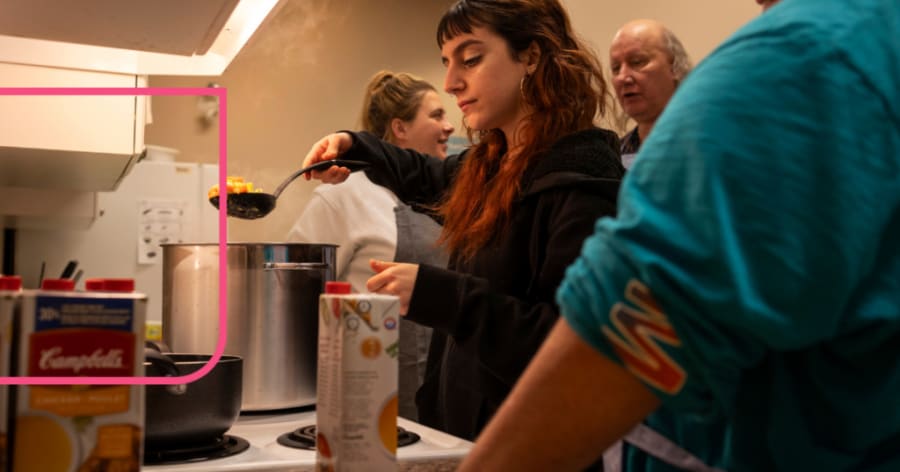 A woman scoops food out of a large pot with a ladle.