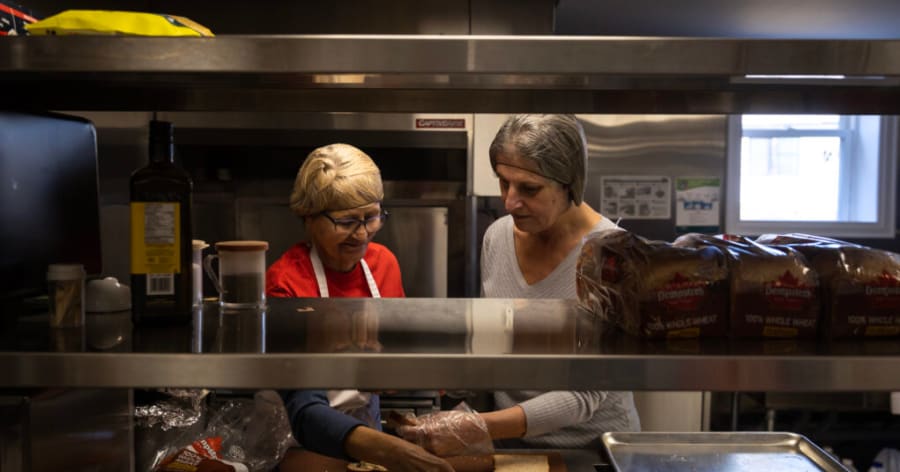 Two woman work in a kitchen.