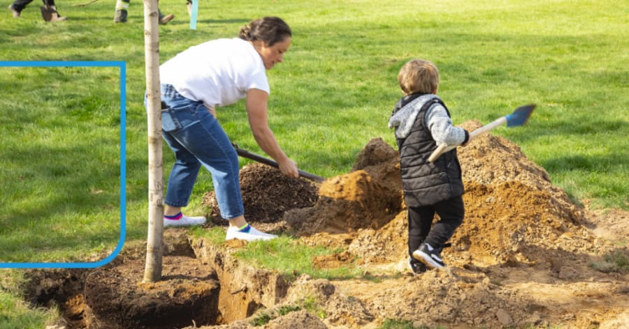 A woman and a young child are digging in the ground.