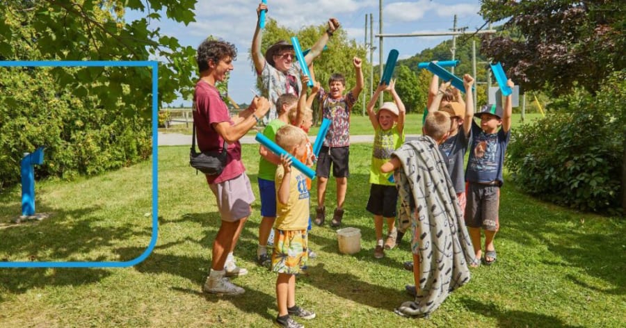A group of kids are standing outside in a circle playing.